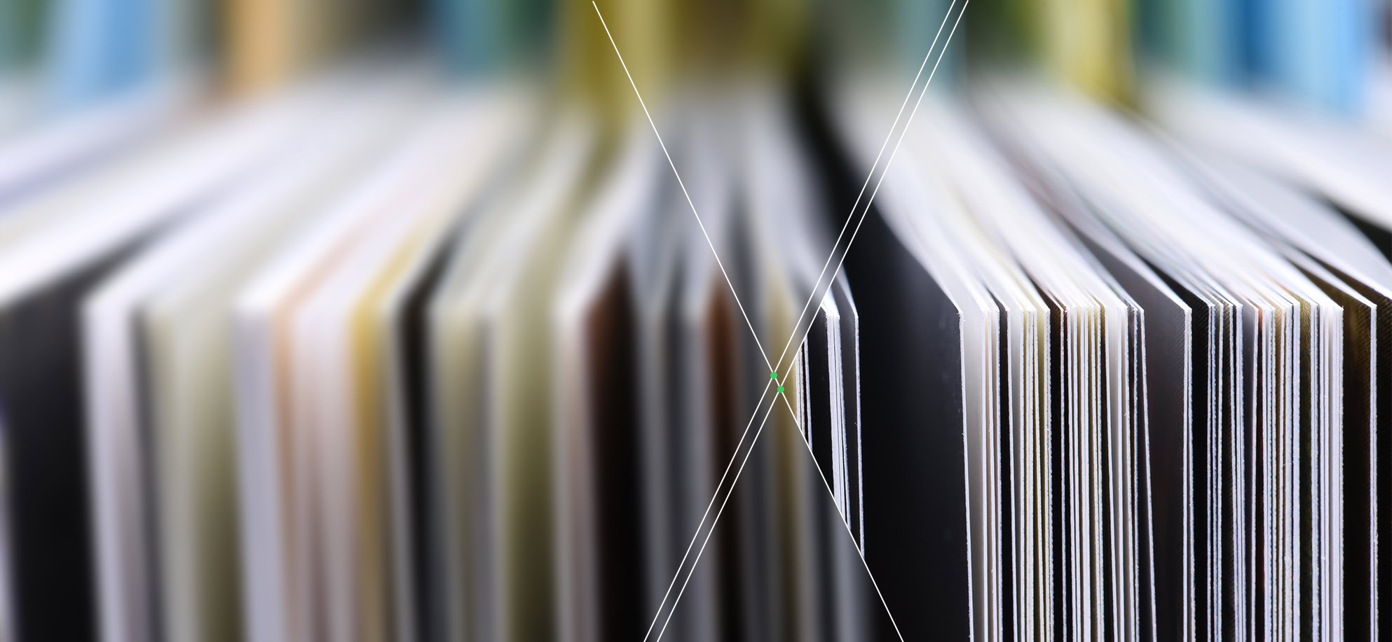 Close-up view of the edges of publications in an archive, displaying pages of different colors and thicknesses lined up vertically.